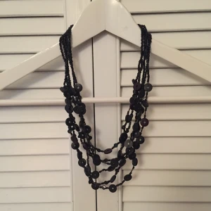  - Halsband i plastpärlor.