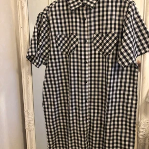 Rutig skjortklänning med hjärt-detaljer - En button-up rutig klänning från lazy oaf. Har bara använt en gång.