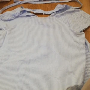 En tunika  - En blå vit randig tunika med ett slags halsband 