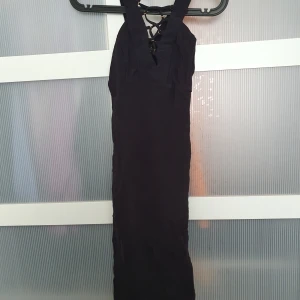 Lacedress strl 6 - Svart slimmad klänning! Snörning i fram och liten slits bak på ca 10 cm. FRAKT INGÅR EJ