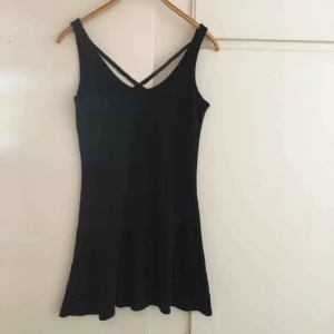  - Fin äldre svart klänning med korsade spetsband i ryggen. Den är lätt figurformad och sitter jättefint på! Skulle säga att den passar en 38 också. 