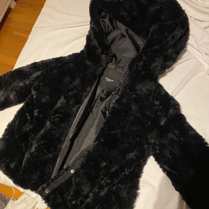 Pälsjacka - Säljer denna svarta pälsjacka! Världens mysigaste jacka med så mysigt material och stor luva🥰 Har aldrig använt och är som helt ny! (Bilderna är tagna från hemsidan men om du vill ha mer bilder på jackan så skriv privat🥰) Nypriset är 400 kr.