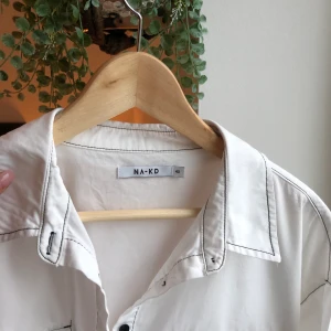 Shorta  - Oversized as fin skjorta med korta ärmar, den är från NAKD och är nästintill helt oanvänd. Funkar till alla olika händelser och stilar. 🧚🏽‍♀️🤍