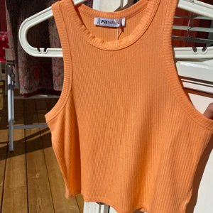 Ribbat linne - Säljer detta ribbade linne i en fin persikofärg (färgen framkommer bäst på bild 3, mycket ljusare i verkligheten) då jag har två likadana. Ganska liten i storleken men passar från xs-m. Använd två gånger! 