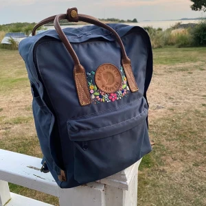 Fjällräven kånken - blommor 🌷  - En jättefin, gullig och unik blå kånken ryggsäck som är nyskick. Köpt på Fjällräven förra året ( 2019 ). Nypris 1500, men är  Handbroderi- Handmade ❤️ budet startar på 900kr och köparen står för frakten ( ca 90kr ) budd: 1100kr