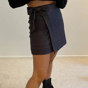 Rutig kjol - Rutig mörkbrun kjol med rpsettknutning i sidan. Strl 36 men passar XS-S. Nyskick 