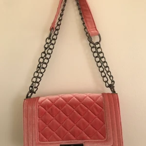 Ljusrosa väska ginatricot - Säljer en ljusrosa axelremsväska från Ginatricot. Är i mycket bra skick, något mörkare på vissa ställen på den sidan som är mot kroppen, men annars i mycket bra skick. Pris, 60kr. Går att hämta på södra Gotland, annars står köparen för frakten. 