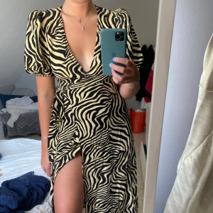 Zebraklänning från Ginatricot  - Omlottklänning med puffärmar i zebramönster från Ginatricot i storlek 38. Använd 2 gånger och därav i superskick. Klänningen är slutsåld på ginas hemsida. Nypris 499kr. Köpare står för frakt💜💕