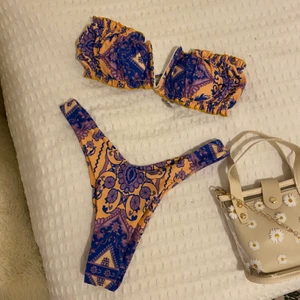 Bikini - blå/lila och orange/gul mönstrad bikini i storlek S. Högmidjade byxor. Tror den kommer från zaful! Ny skick