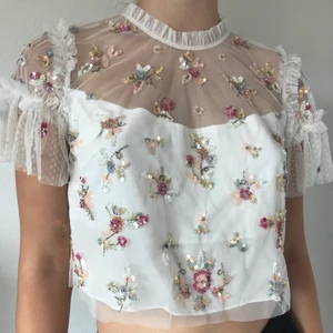 Steptstopp från Needle & Thread - Helt oanvänd spetstopp från Needle & Thread, utsmyckad med paljetter och volanger. Stl 40 men skulle säga att den passar från stl 34-40. Nypris 2033kr. Priset kan duskuteras. Frakt ingår!