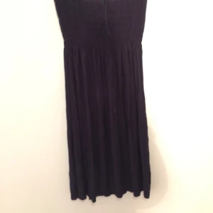  - Mörkblå tubklänning med resår över bröstet så passar dom flesta storlekar. Köpt i Spanien. Aldrig andvänd. 
