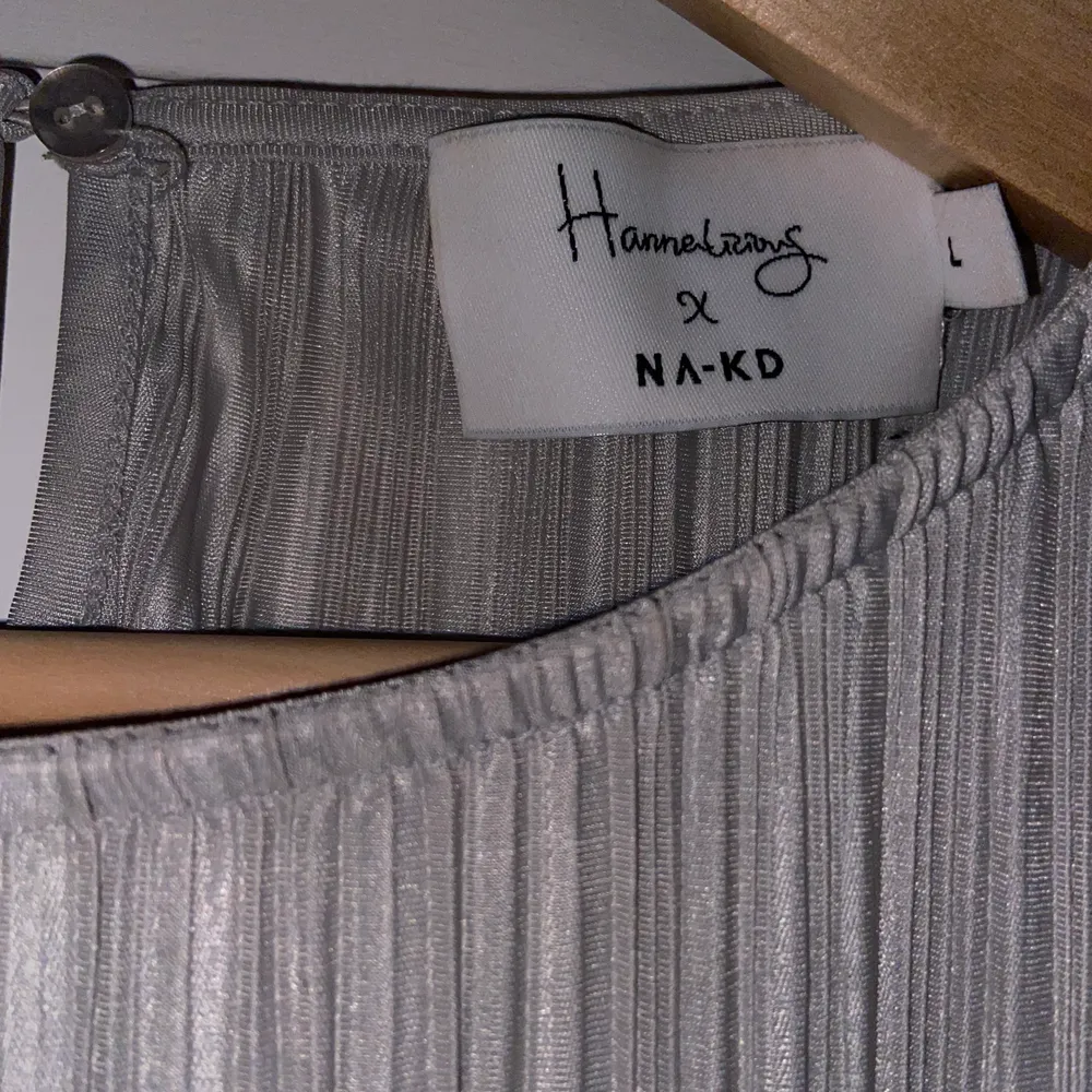 En silvrig/grå blus från NAKD x Hanna Licious kollektion, storlek large men den är kort så den är lite mindre i storleken. Jätte fint skicka aldrig använd. Skriv för fler bilder!!. Blusar.