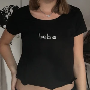 T-shirt med rhinestones  - En svart t-shirt med ”bebe” i rhinestones✨Har själv limmat på diamanterna därför vet jag inte hur den klarar tvättmaskinen. T-shirten är annars helt oanvänd då jag endast skaffade den för en diy. (Köpare står för frakten, 44kr📦) BETALNING SKER VIA SWISH 