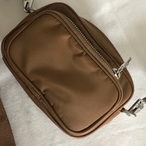 Nylon Mini Camera Bag. 💼 🧳 ARKET - SÄLJER MIN FINA ARKETVÄSKA!! Köpt för 490 kr (org pris) ca ett år sen, använd ett fåtal gånger, max 3. Superfint skick!! Axelbanden går att byta mot andra då de är avtagbara. Har totalt 3 fack vilket gör den rymlig. 14,5cm bred 9cm hög!
