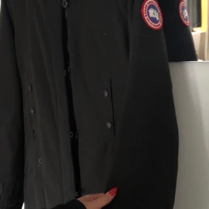 Lång vinterjacka, Canada Goose - Super skön, lite längre vinterjacka från Canada.  Storlek: Lite större S, passar även M och vill du ha den tajt passar den L.  Pris: Inget kvitto finns kvar samt ingen päls på luvan, där av det låga priset!  (Kan mötas upp i Stockholms området, även fraktas MEN köparen står för frakten).