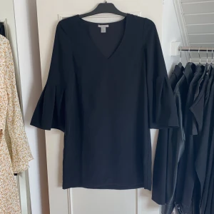 Klänning - Svart v ringad klänning med volangärm. Storlek 36