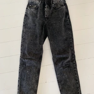 Momjeans H&M - Säljer mina momjeans från H&M. Väldigt mörkgråa så man kan nästan säga svarta, dock lite stonewashed så inte helt svarta. Knäpps med knappar i midjan och de är snyggt slitna nere vid ankeln. Säljer för 150 kr!🤍