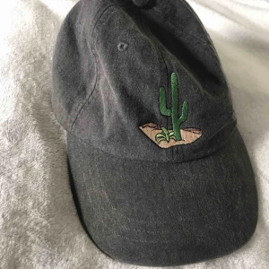  - Grå keps i ”dad cap” passform med kaktus på framsidan. Knappt använd, i princip som ny. Finns i Solna/Stockholm, samt kan jag ta med till Malmö då jag pendlar dit. 