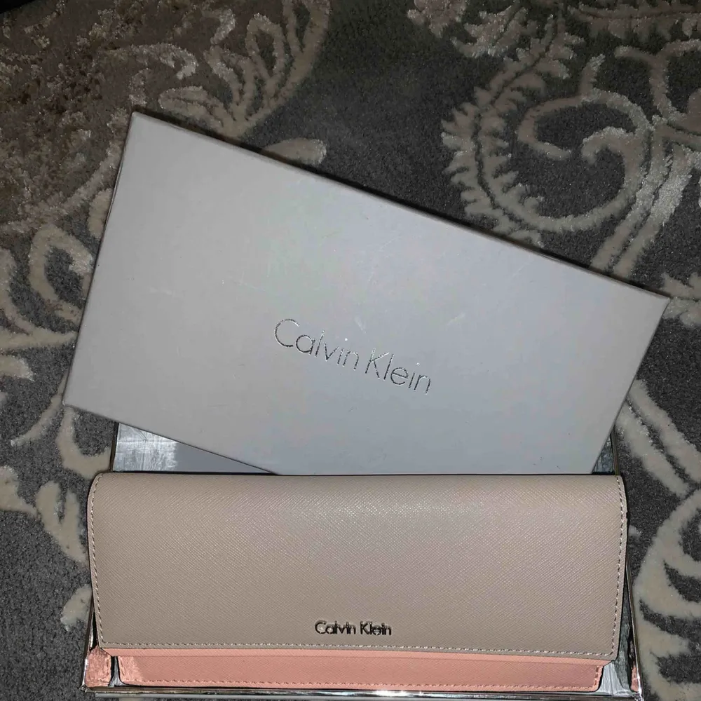 Oanvänd Calvin Klein-plånbok till salu, kan även användas som clutch. Äkta och helt oanvänd. Möts upp i centrala Göteborg, annars står köparen för frakten (spårbart).. Väskor.