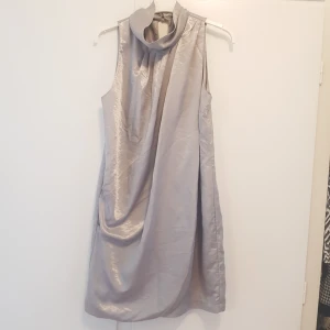  - Klänning i silver. Nyskick. Storlek 38 från gina tricot. Passar fint till fest & nyår