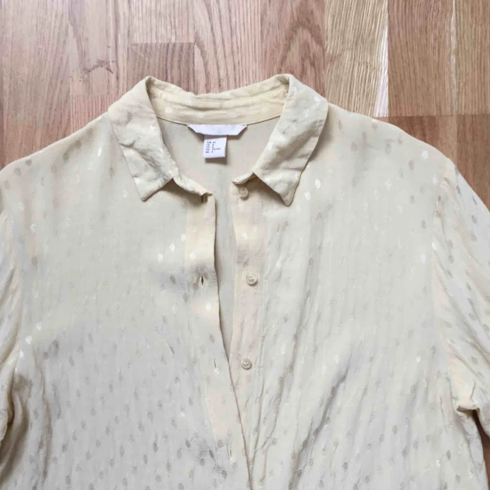 Ljusgul skjorta från H&M. Blanka prickar i tyget. Hel och ren, men kanske skulle må bra av att strykas ordentligt. . Skjortor.