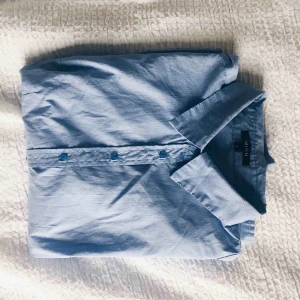  - Snygg feminin skjorta. Sömmar över bysten. Gott skick. Det enda som är slitet är lappen i nacken (se bifogad bild)