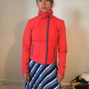  - Suuupersnygg tunn jacka från hästmärket CRW i en orange-röd färg. Lite asymmetrisk dragkedja och bra sportigt material. Köpt för ca 500