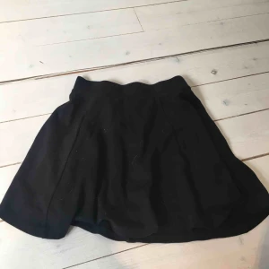  - Kjol med ”volangform” från HM. Svart, stretchigt material och silverdragkedja bak. Nyskick. Köpt för kanske 200-300 kr