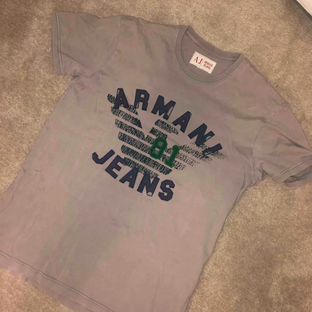 Grå Armani Jeans vintage tröja. Köpt på Humana för typ 100kr. Super i skick. Storlek är oklar men jag skulle säga att den passar S till M.  Kan mötas upp eller posta! Pris kan diskuteras!. T-shirts.