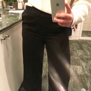  - Bekväma fladdriga svarta byxor med vita små ränder. Skulle passa storlek 40 också. Annars bra passform och använda endast en gång. Nypris: 300 kr.