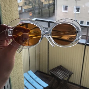  - Helt oanvända solglasögon med orange glas.