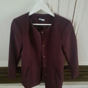  - Snygg fåtal använd vinröd/lila kappa med knappar.