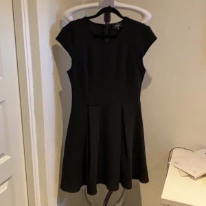 Klänning  - Säljer en utsvängd svart klänning som sitter tajt ner till midjan. Gör sig mycket finare i verkligheten. Den är i bra skick och använd fåtal gånger. Köparen står för frakten 