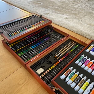 Målarlåda i trä - Olje- akryl & akvarellfärg, blyertspennor, oljepastell, penslar, färg- & tuschpennor. Originalpris 500kr. Rekommenderar om du ritat nån månad och vill prova olika material. 3 tuber öppnade, pennvässare & en krita borta, oanvänd. Köpare betalar frakt.