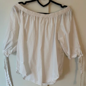 Blus storlek 34 - Vit off-sholderblus från HM. Storlek 34 men passar även större storlekar tack vare resoren kring axlarna. Sparsamt använd. Frakt tillkommer ✨💞