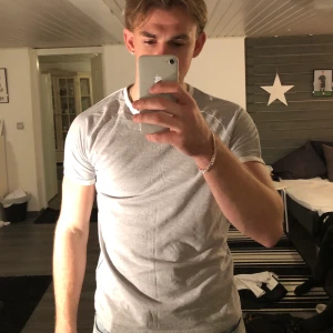 Grå T-shirt med vita ränder på armar - Bra skick, varsamt använd