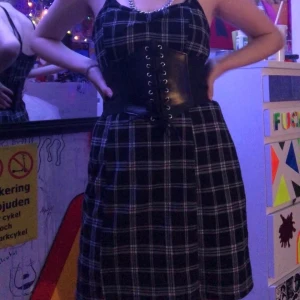 Rutig klänning  - Cool rutig klänning som går ner till knäna (korsetten ingår inte)tror den är köpt på NewYorker för typ 150kr. Har själv suttit en säkerhetsnål för att forma kanten lite. Köparen betalar frakt 