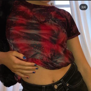 röd spräcklig tee - röd,svart, glittrig vintage tröja😍 cond: 9/10! stylad tillsammans med våran svarta fluffy bag, även den ligger ute och går att köpa!😍