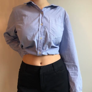 Skjorta i ljusblått - Skjorta från Gap som är jättesnygg att ha både croppad knuten bak eller hängande ner! Står XL i men skulle säga att den passar allt mellan XS och XL beroende på hur man vill att den ska sitta!