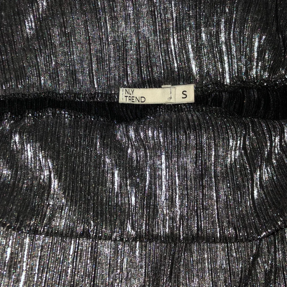 Silverfärgade plisserade byxor från Nelly, använda en gång. Går också att vänta ut och in för svarta plisserade byxor, men snyggast som silvriga. . Jeans & Byxor.