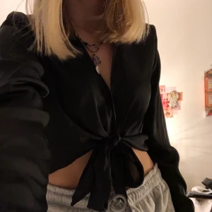 Svart knyt topp strl xs - En jätte söt svart knyt skjortliknande topp i ett luftigt material. Köpt i början av sommaren men har bara använt den 2-3 gånger så säljer nu:)