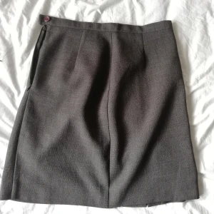 Grå, kort pennkjol med slits - Grå, kort pennkjol med slitz baktill. Står italiensk storlek 42, men skulle uppskatta till svensk storlek 36 ca. 