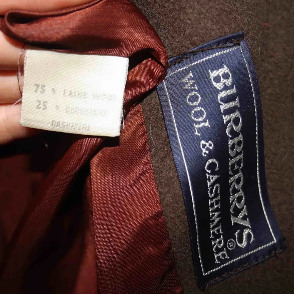 Burberry kappa i ull och Kashmir.  Söt, ser inte så ”maskulin” ut som på bilden. Sitter oversize på mig, S-M. Den tar slut på mitten av låret. Se sista bild slitage  Möts i Stockholm eller så betalar köparen för frakt . Jackor.