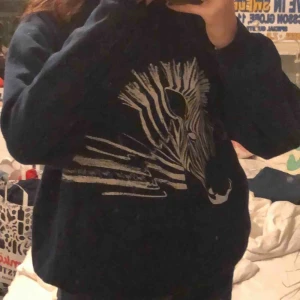  - en mörkblå tröja med en zebra på