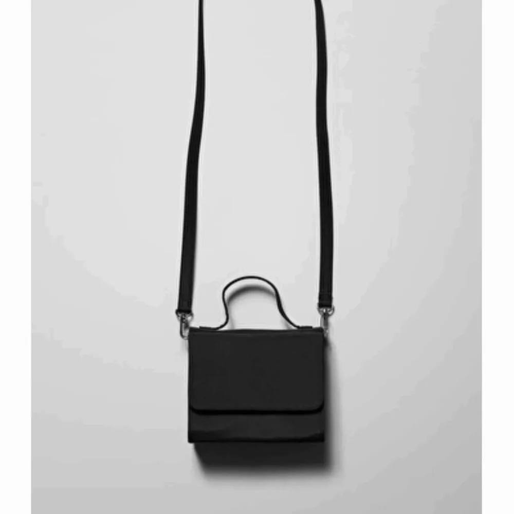 Säljer denna lilla handväska från weekday, ej exakt samma som andra bilden för min är i lack inte tyg, men samma modell!!. Väskor.