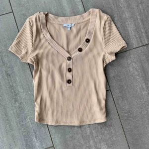  - navellång,beige t-shirt. använd 1 gång! frakt tillkommer