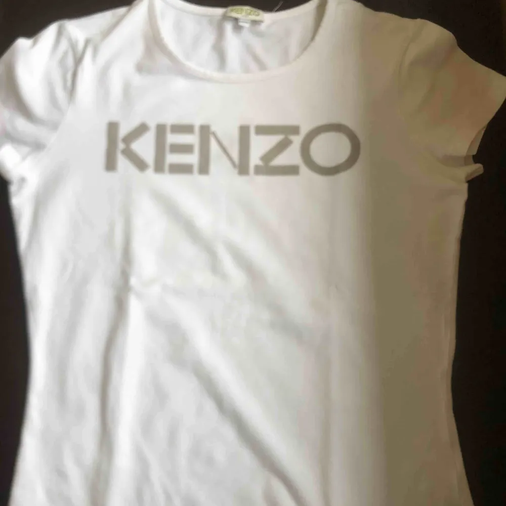 Hej! Säljer en vit Kenzo Tshirt med silvrig text. Köpt på Nk barnavdelning för 800kr. Den är använd fåtal gånger och finns inga tecken på slitage. Frakt ingår inte, pris är diskuterbart. . T-shirts.