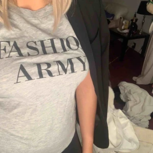  - En grå T-shirt med trycket ”Fashion army” från gina tricot. Köpt för något årsedan men enbart använd ett fåtal gånger. Köparen står för frakt 