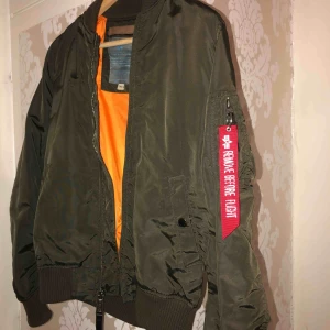  - En Alpha militär grön bomberjacka som är i helt nytt skick.