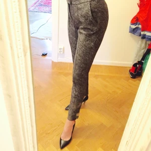  - Eleganta svart/gråmelerade byxor från Tiger i mjukt följsamt tyg. Väldigt bekväma! Använda ett fåtal gånger så i fint skick.